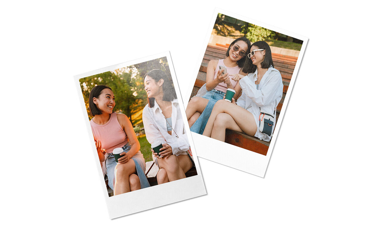 Twee vrouwen zitten in het park en praten. Een houdt een koffiebeker vast.