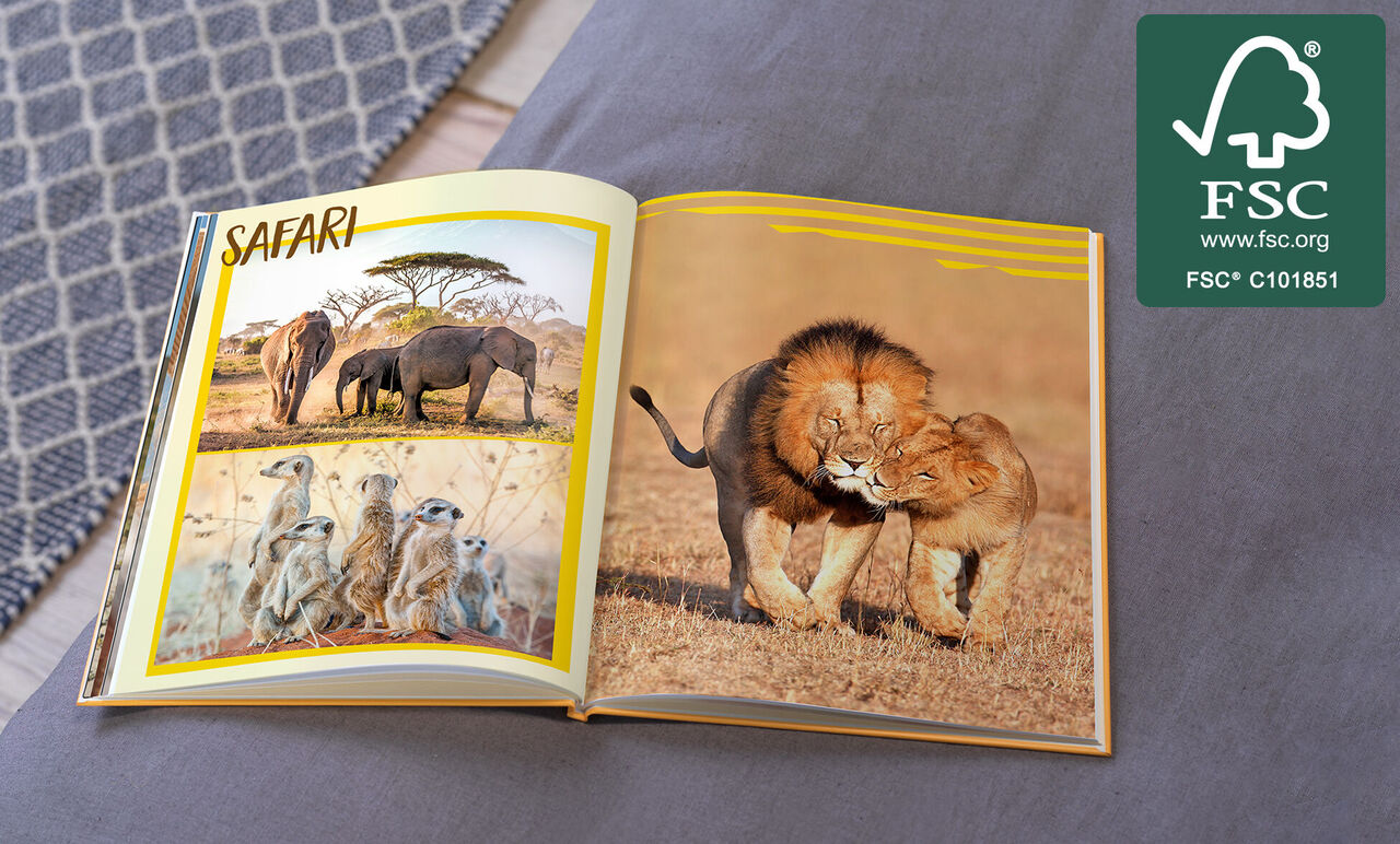 Een geopend fotoboek met safarithema. Links staan olifanten en stokstaartjes, rechts twee spelende leeuwen.