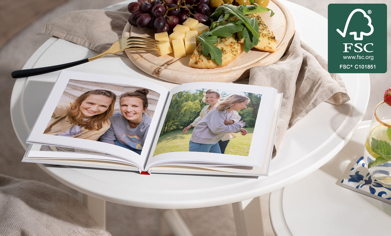 Een open fotoboek op een tafel met verse producten. Op de pagina's spelen twee kinderen buiten.