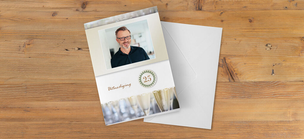 Hoogwaardige CEWE-kaarten voor een 25-jarig jubileum, liggend op een houten tafel.