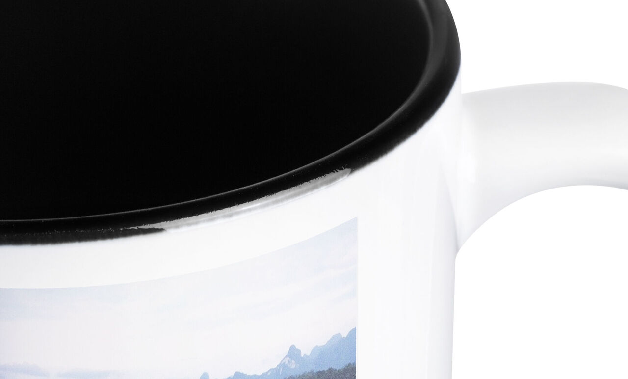 Detailopname van een witte beker met een landschapstaferelenmotief