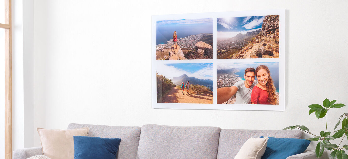 Een groot wanddecor met reismotieven. Links boven persoon op berg met uitzicht; rechts boven stad overzicht. Onder links bergen; onder rechts moment.
