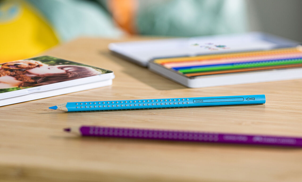 Kleurrijke pennen op houten tafel met fotoboek op de achtergrond
