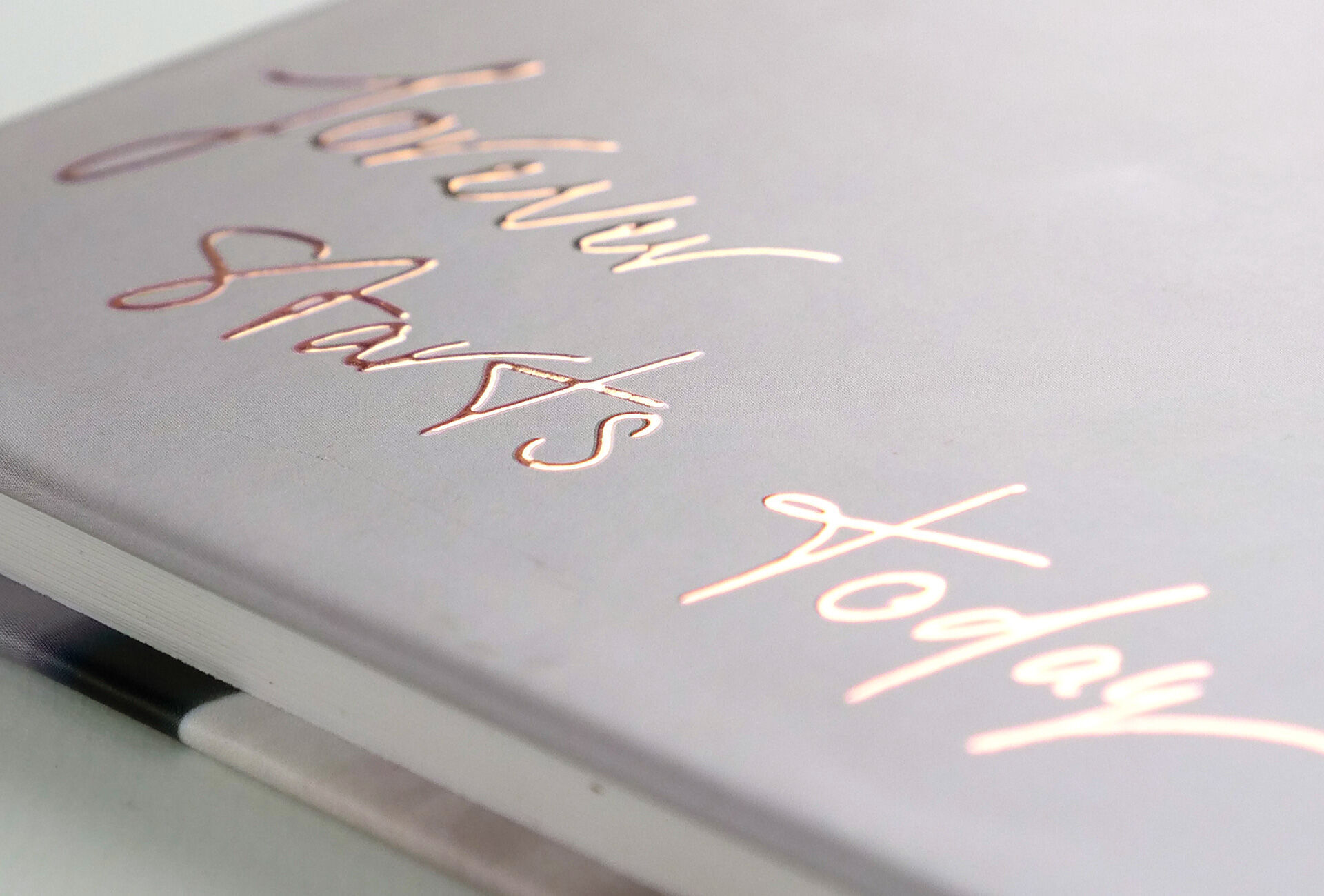 Een fotoboek met een creatieve, handgeschreven titel op de cover. De tekst is ontworpen in sierlijke roségouden letters.