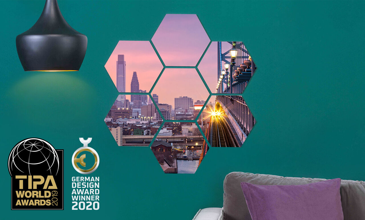 Kleurrijke wanddecoratie met hexagonale foto's van een stad, zonsondergang en brug