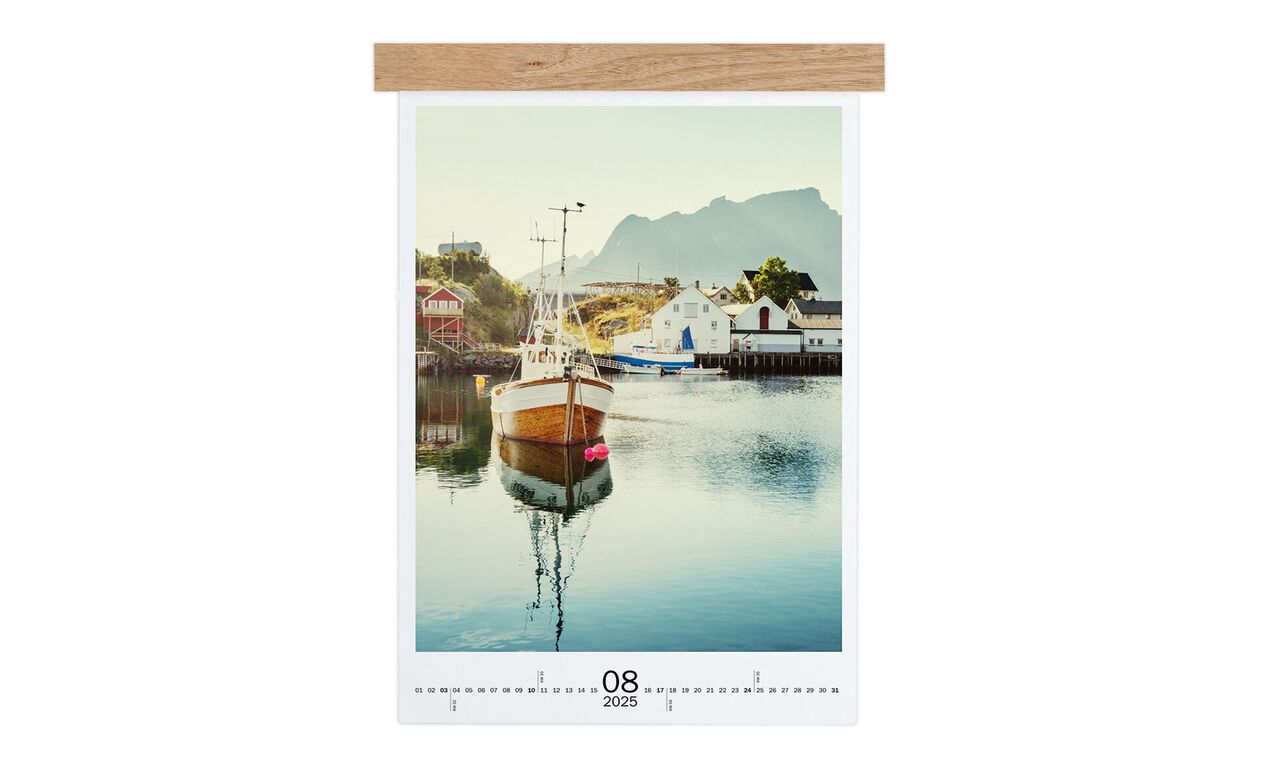 Een liefdevol ontworpen wandkalender met een foto van een boot in kalm water, omgeven door bergen.