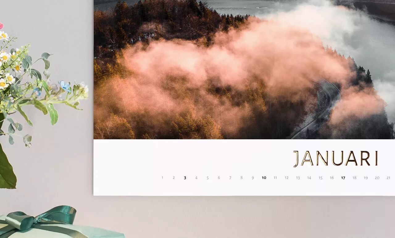 Een inspirerende januari-pagina in CEWE Fotokalender met mistige bomen en zachte zonsopgang