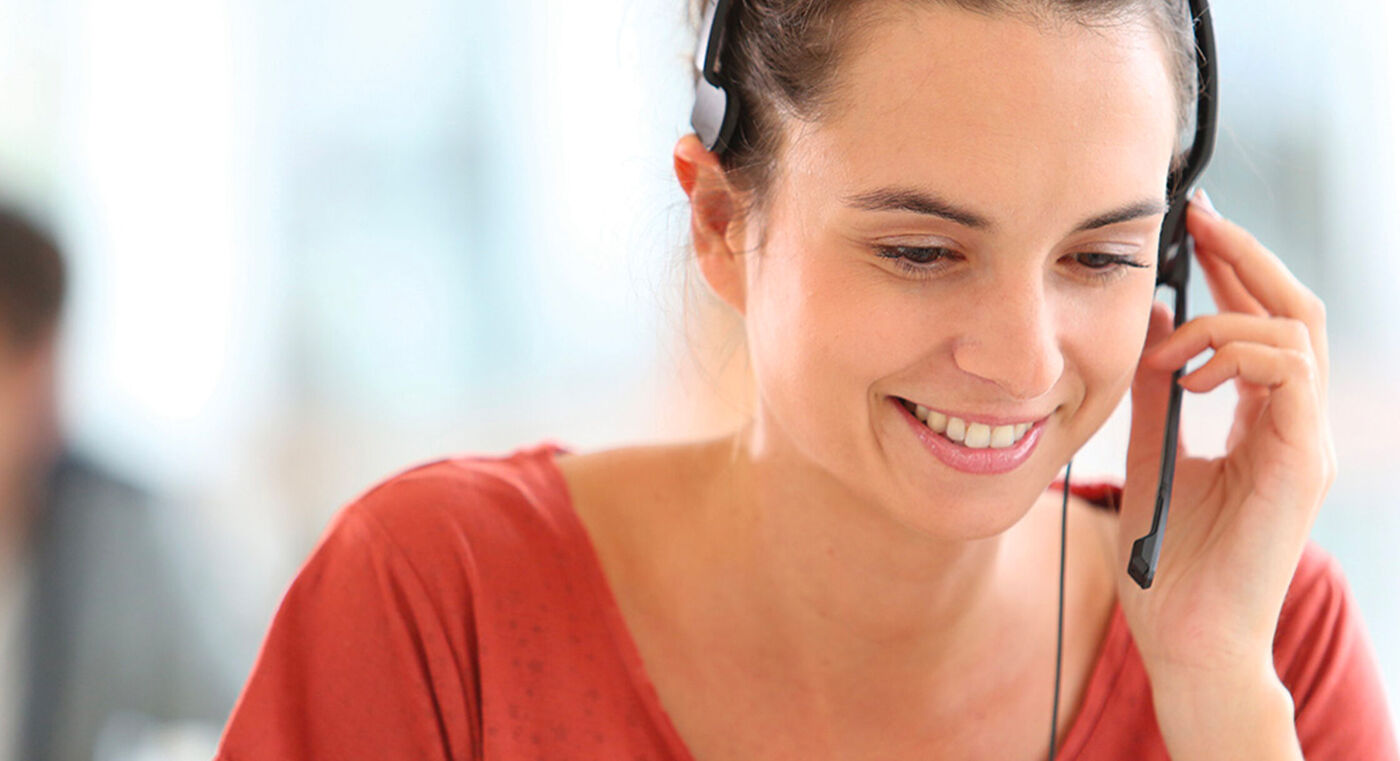 Vrouw met headset voert een telefoongesprek, ontspannen sfeer