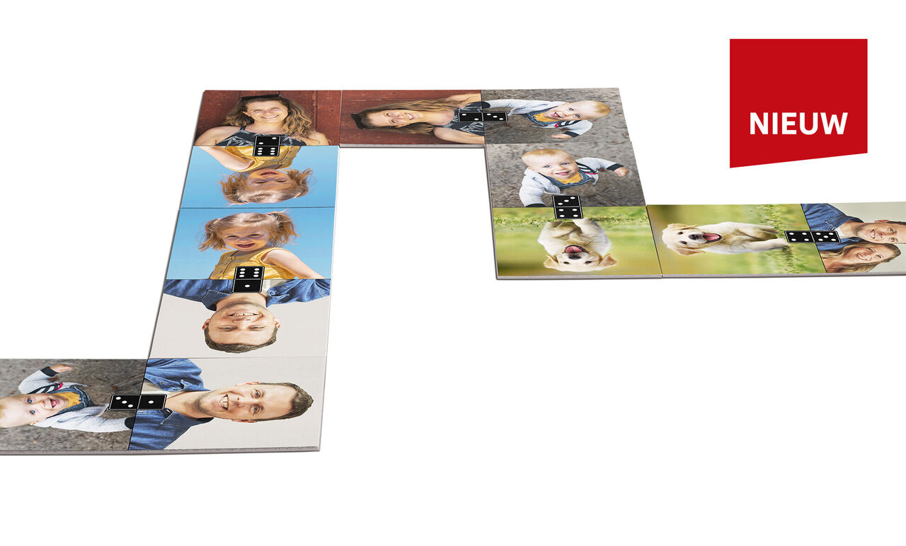 Kleurrijke dominostenen met foto's van mensen en honden, sommige rechtopstaand. Aan de rechterkant staat 'NIEUW' in rood.