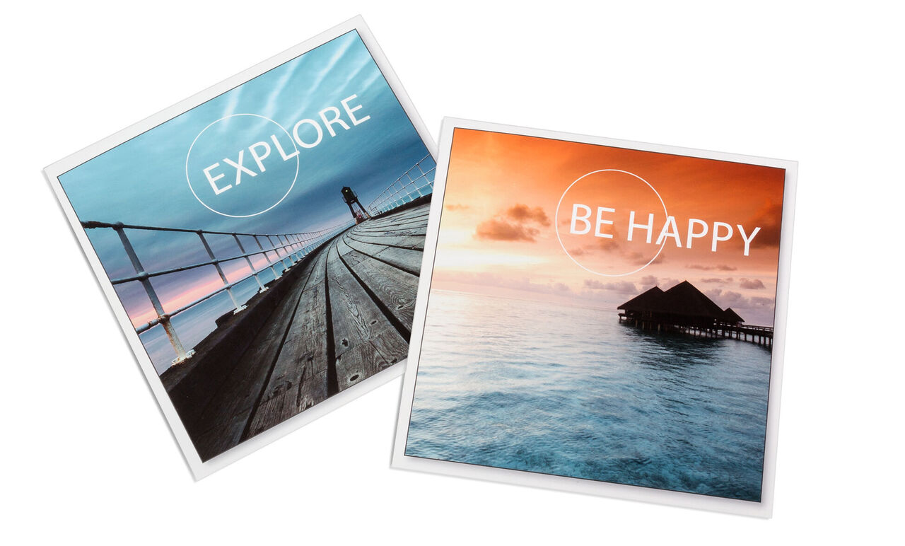 Twee schilderijen met inspirerende spreuken: een brug bij zee en een idyllisch water met 'EXPLORE' en 'BE HAPPY'.