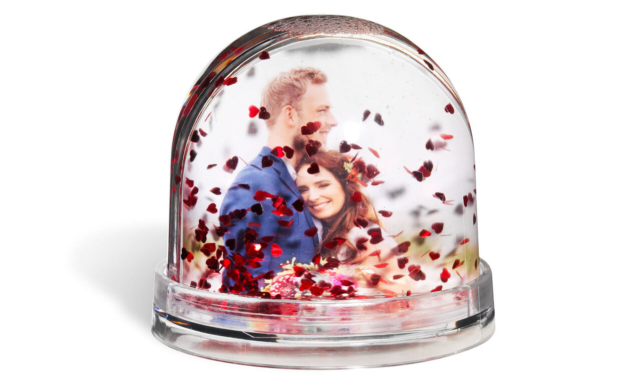 Prachtige sneeuwbol met verliefd paar en hartjesconfetti.