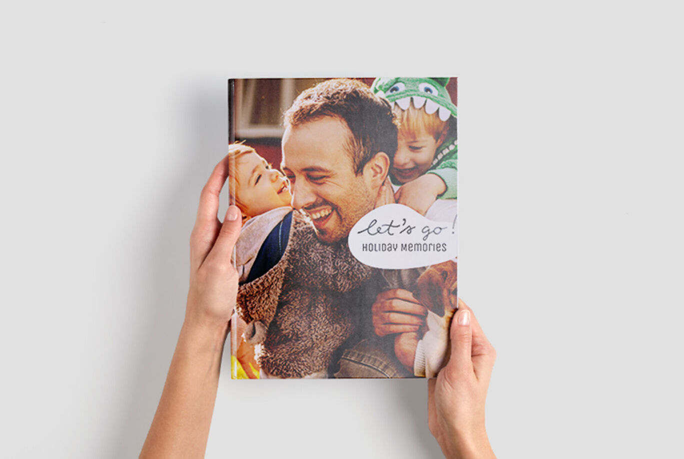 Iemand houdt een fotoboek getiteld 'Holiday Memories' vast. Het omslag toont vakantiefoto's vol liefde.