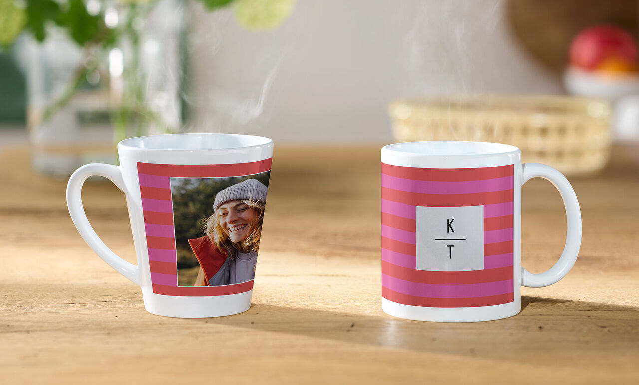 Twee individueel ontworpen mokken met roze-rood streepjespatroon, één met foto en één met de initialen K en T.