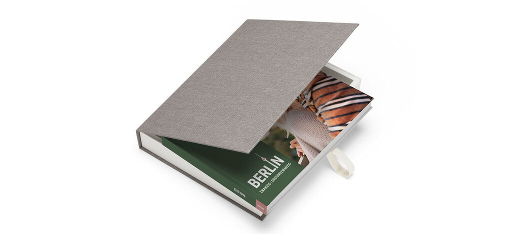 Een open CEWE FOTBOEK met een welkomstgroene pagina en een foto van Berlijn.