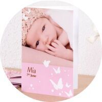 Een prachtig CEWE fotoboek met een baby en schattige haarband. De naam Mia staat op de kaft.