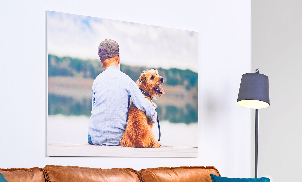 Een jongen met een blonde hond geniet samen aan het meer.