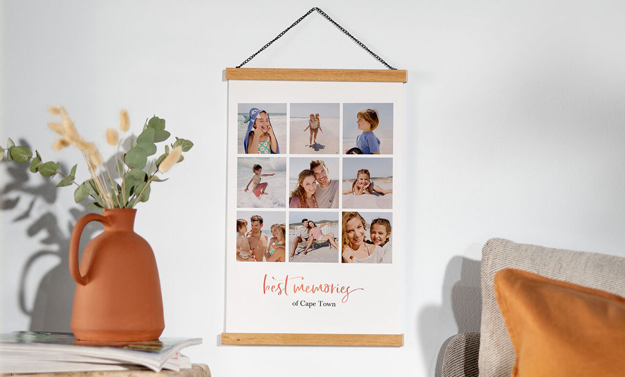 Een hangende poster met meerdere foto's van vrolijke kinderen op het strand, omringd door een vaas met droogbloemen.