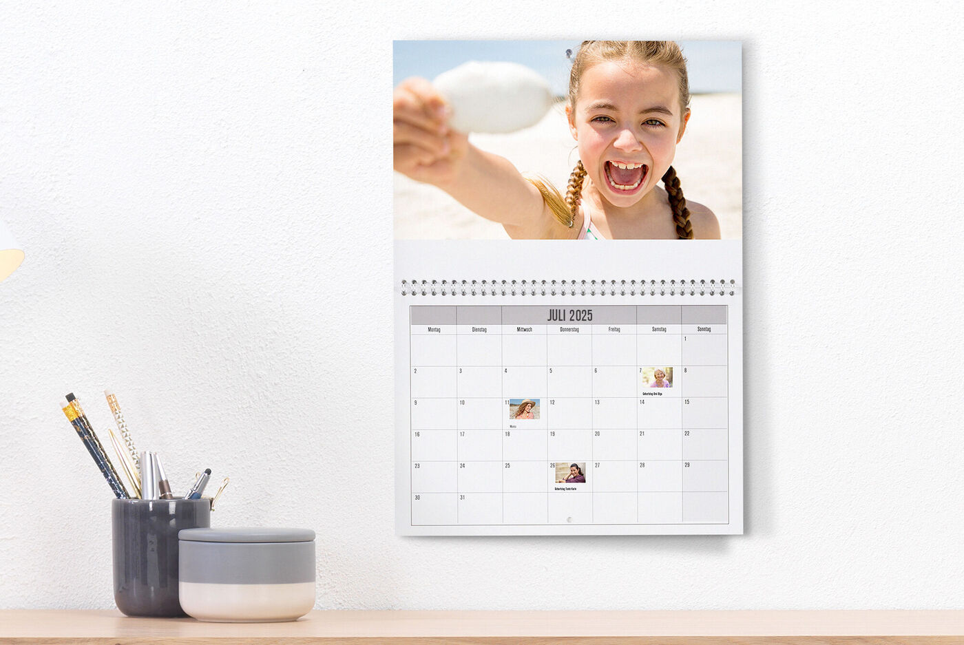 Een persoon houdt een lepel op het strand voor een kalender.