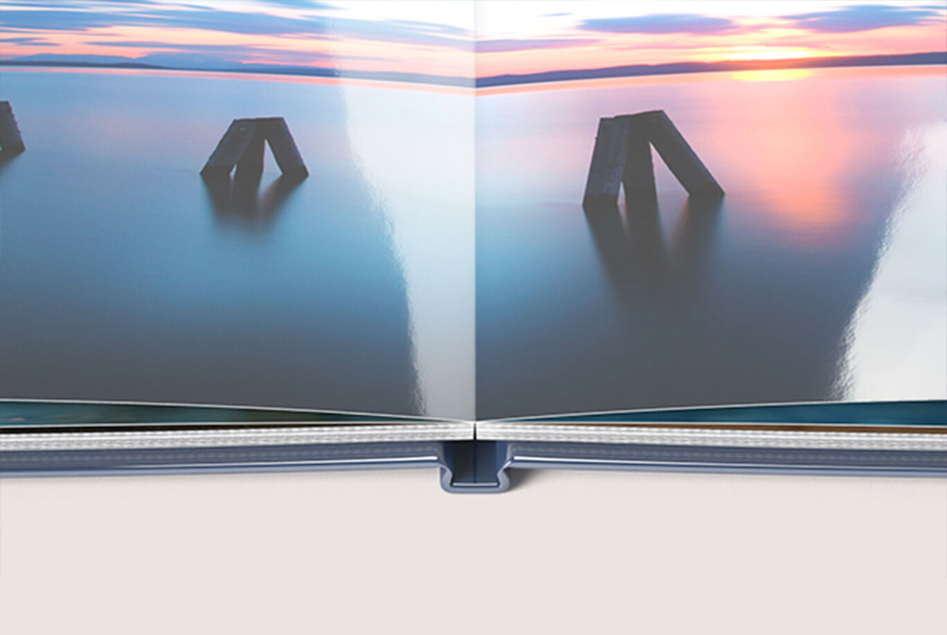 Twee opengeslagen pagina's van een CEWE FOTOVOEK met een rustig waterbeeld bij zonsondergang.