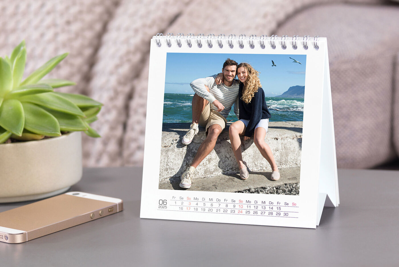 Een paar poseert voor een kustlandschap in een tafelkalender.