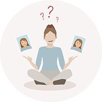 Jonge vrouw zit in meditatiehouding en houdt twee foto's met verschillende gezichten in haar hand, ze lijkt nadenkend.