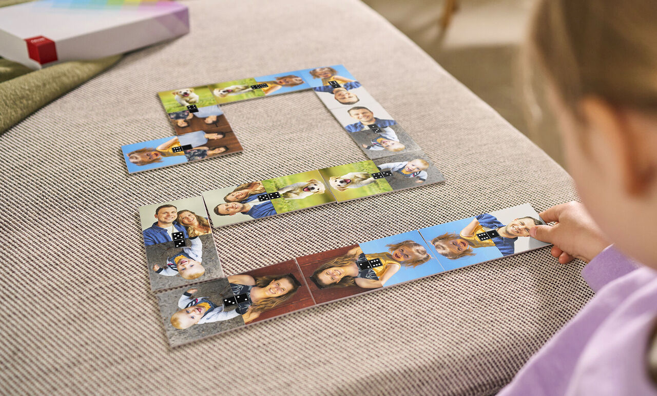 Een kind speelt met een fotopuzzel met verschillende persoonlijke foto's.