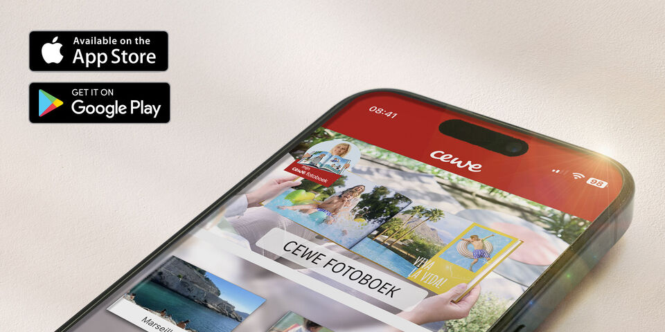 Smartphone toont de CEWE FOTBOEK-app met kleurrijke fotoboeken.