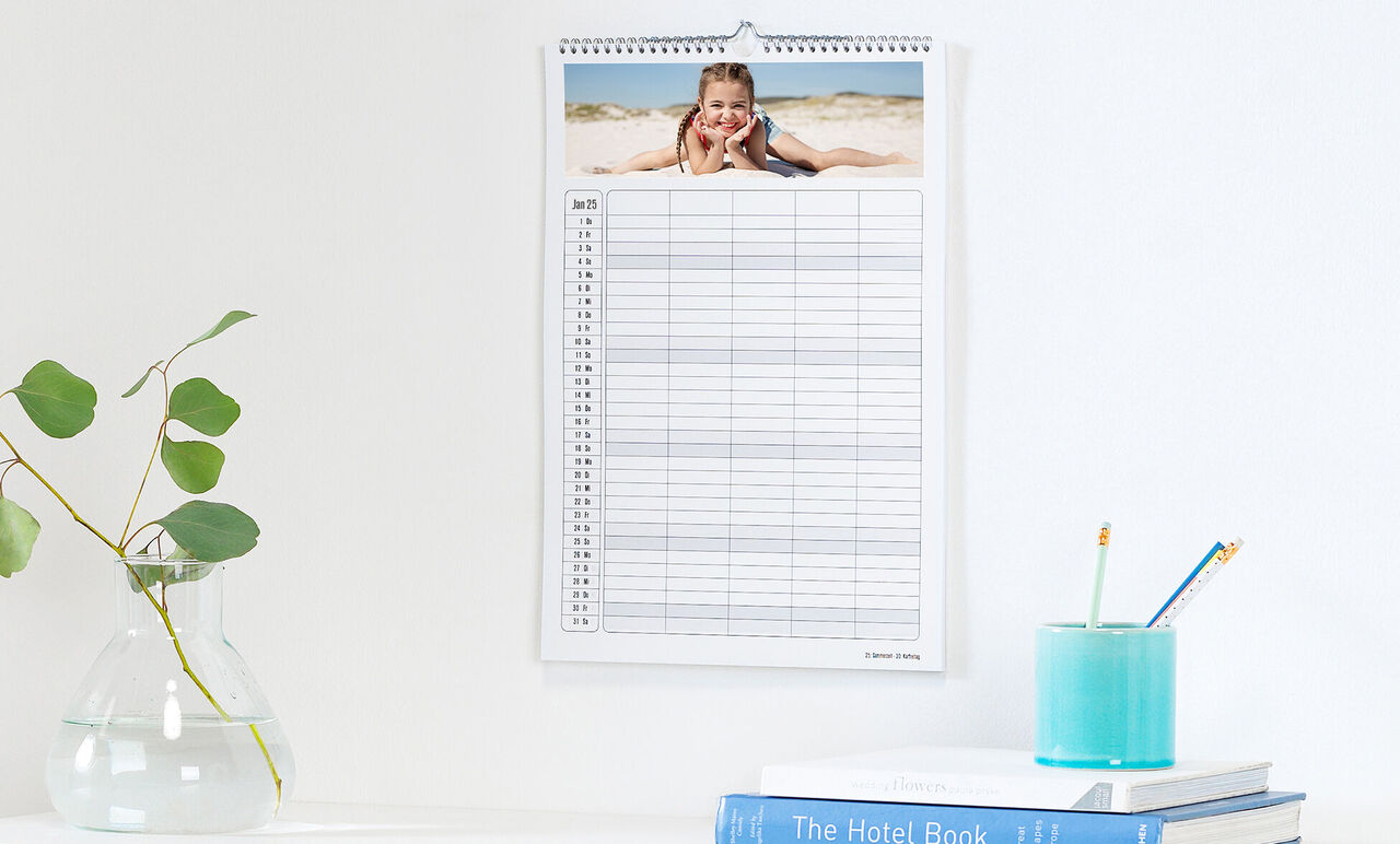 Een mooie fotokalender hangt aan de muur met een foto van een vakantiedag op het strand.
