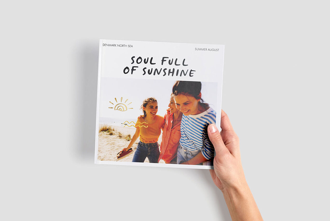 Persoon houdt een CEWE Fotoboek met de titel 'Soul Full of Sunshine' vast