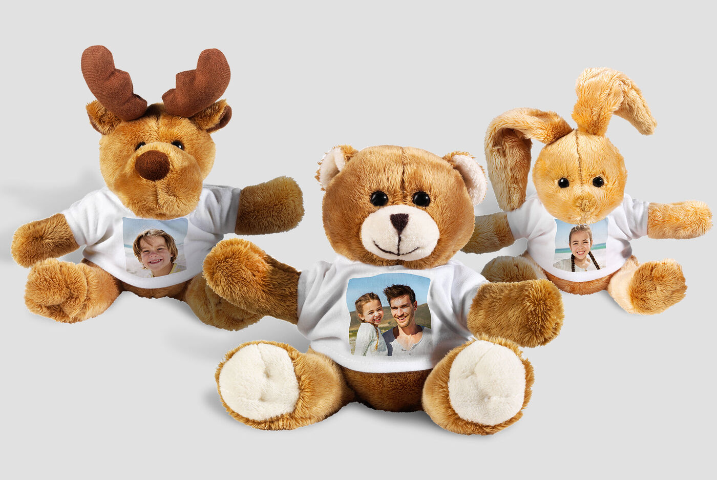 Drie pluchen knuffels met foto’s op hun shirts die vreugde uitstralen