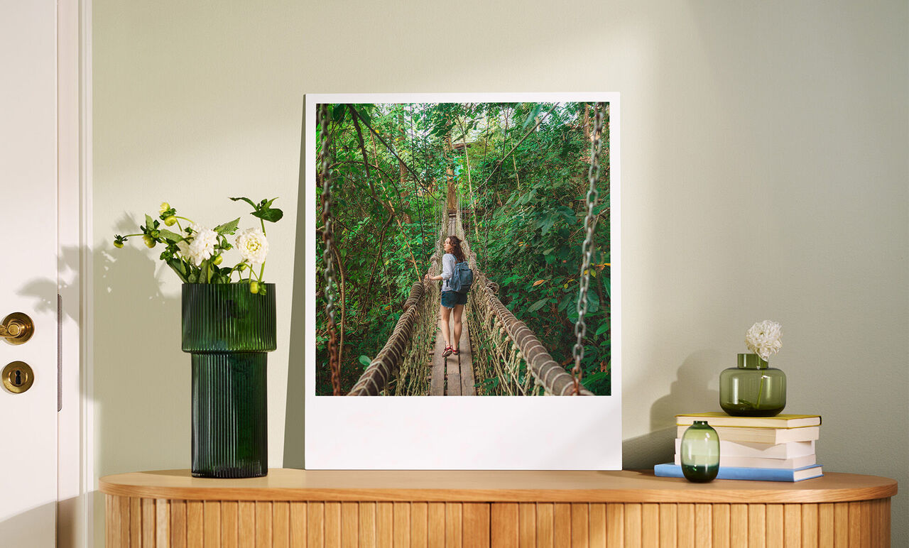 Twee mensen genieten van een wandeling over een hangbrug in een groene bos.