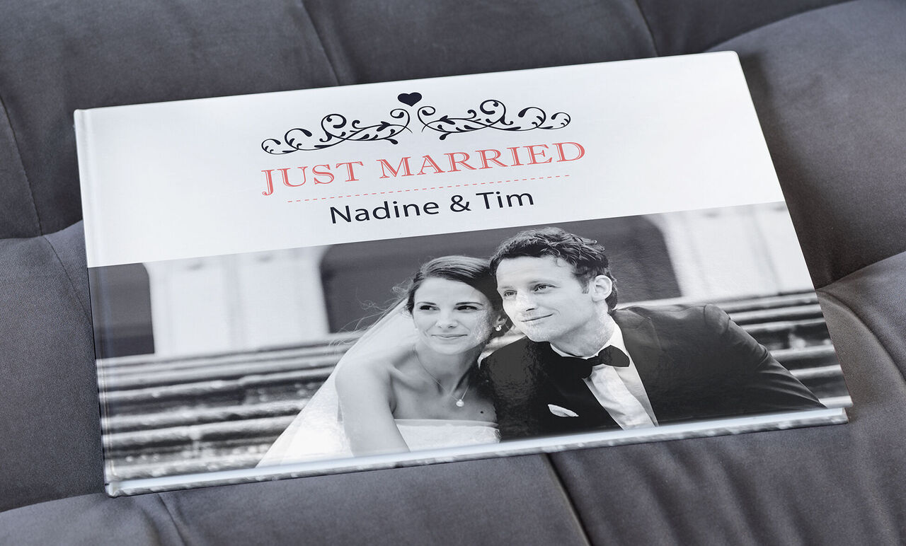 Het CEWE FOTOBUCH toont de omslag van een huwelijksboek met de namen Nadine en Tim.
